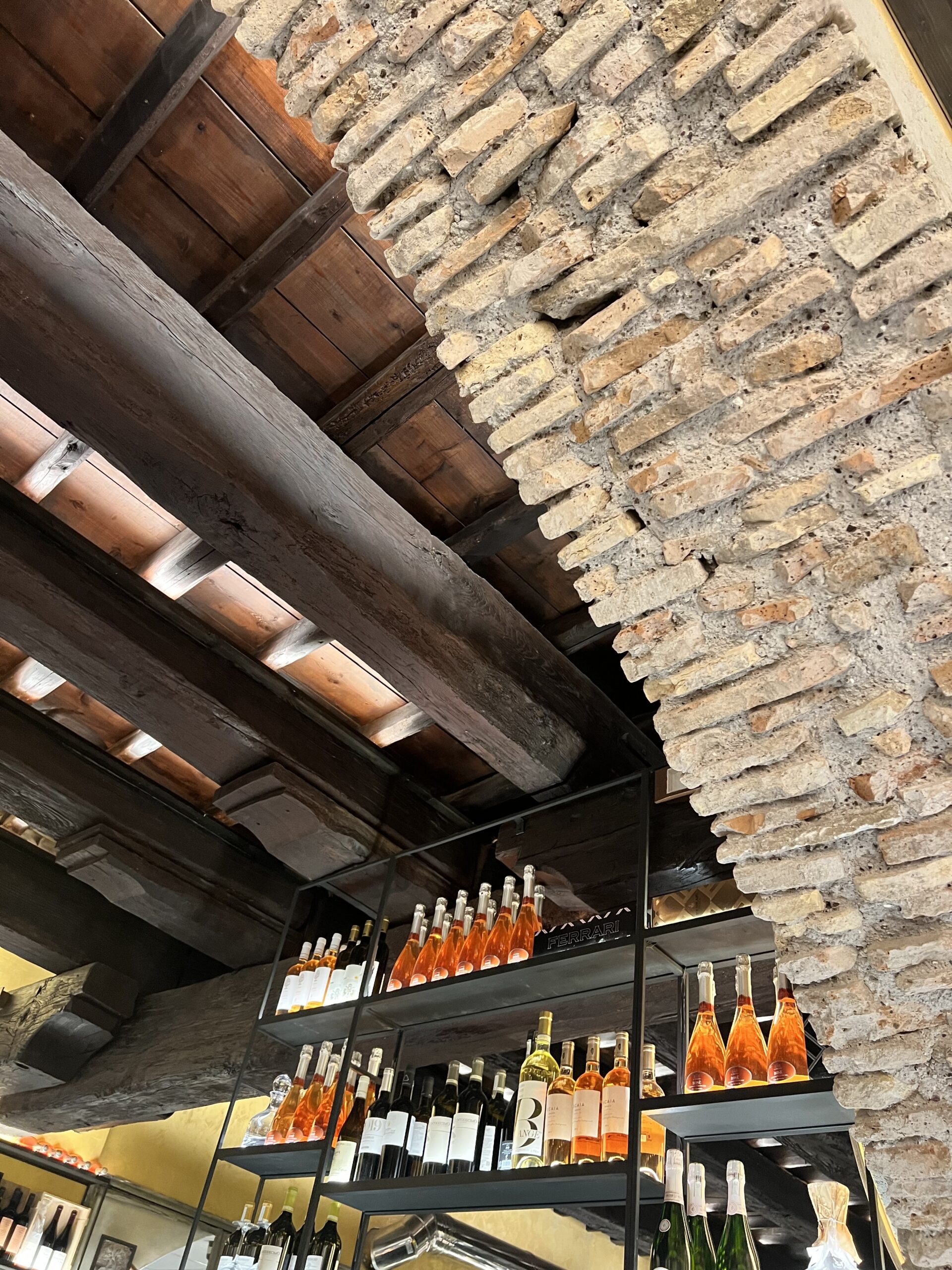 rustic archway and wooden beams on the ceiling with a tower of wine